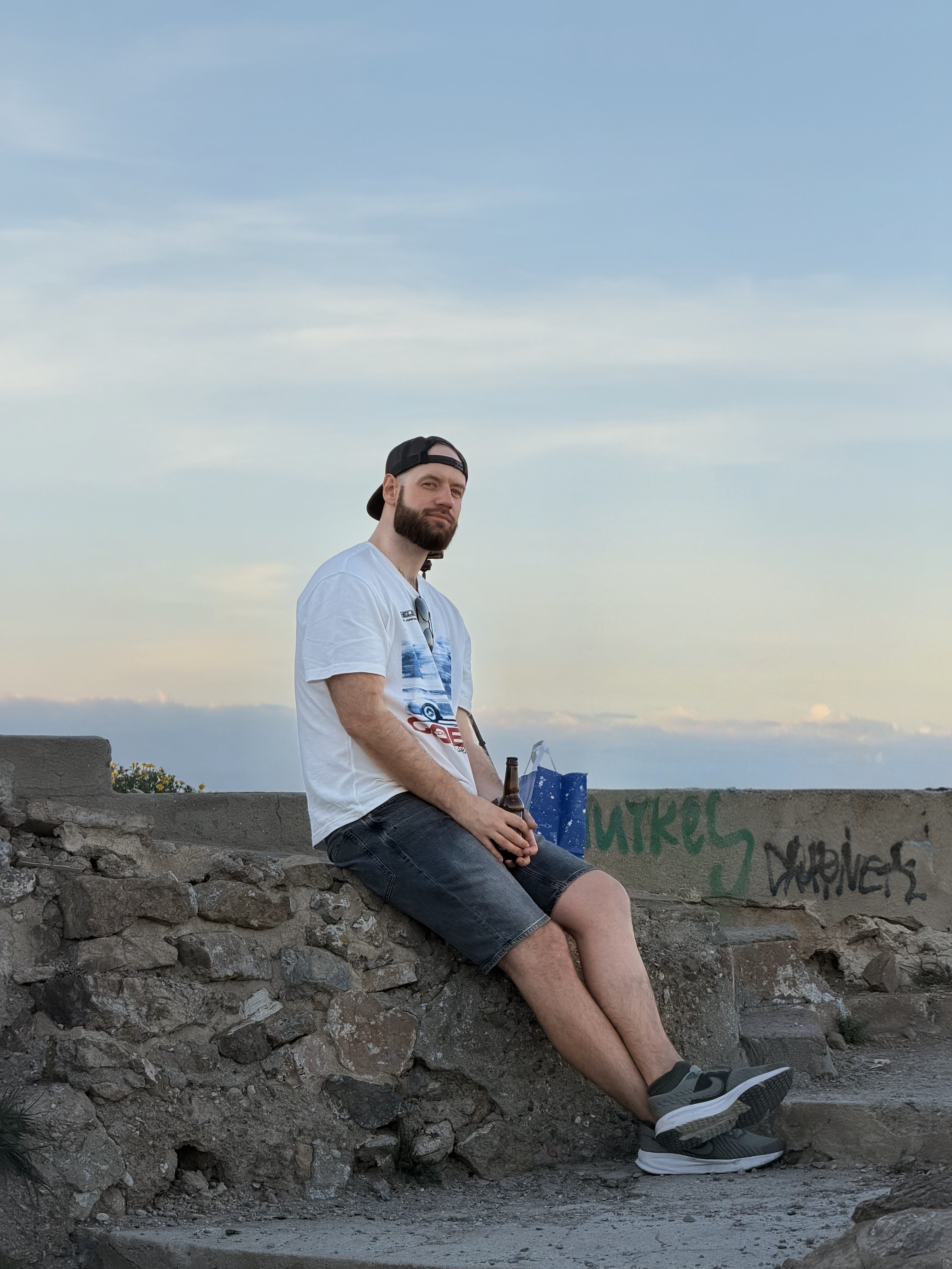 Pavel Veselý sitting on a stone wall outdoors